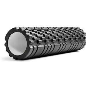 A black foam roller is laying on the ground.