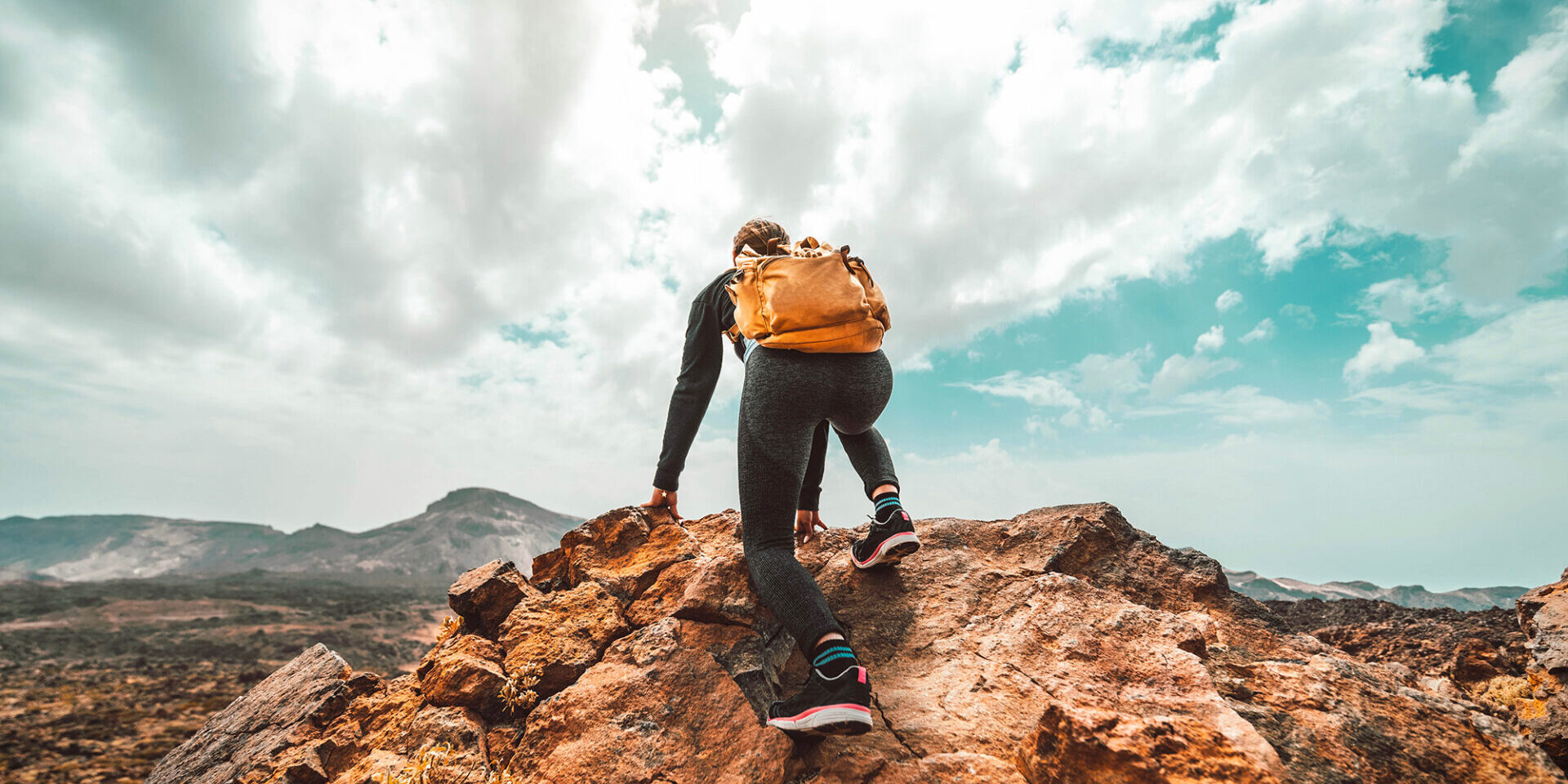 Woman with backpack hiking mountains - Hiker climbing on the top of the cliff - Sport, success, leadership and lifestyle concept